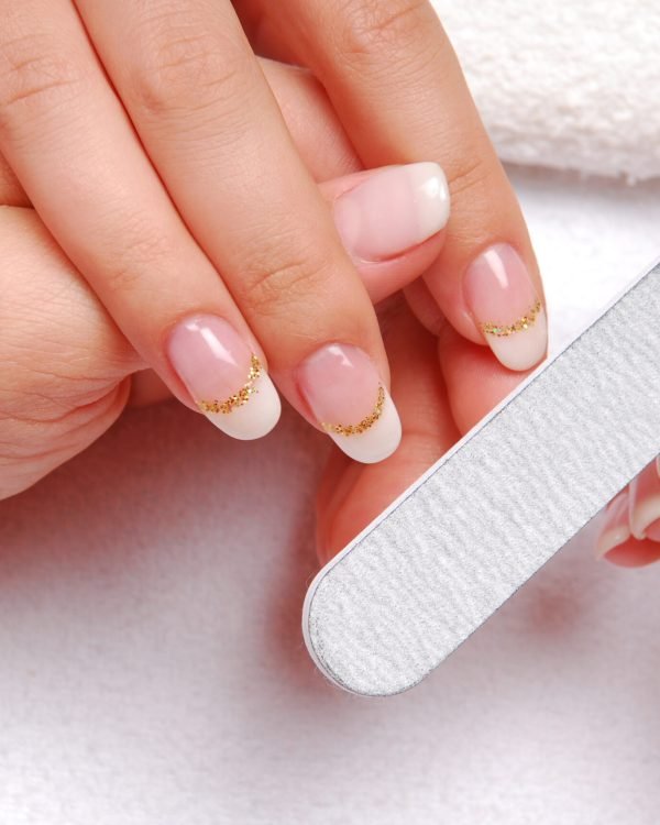 beautician polishing female nails.